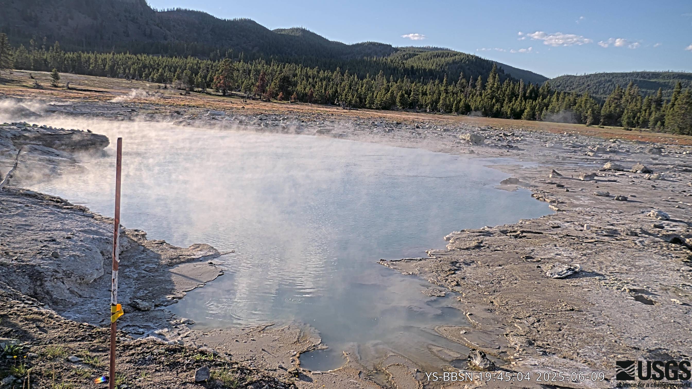 Looking at hot spring with high cliffs in the background